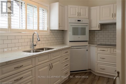 A kitchen with white cabinets and a white oven.