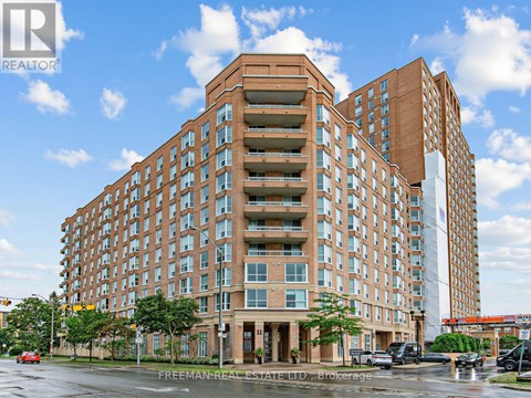 A large brick building with many windows and balconies, with the words "Freeman Real Estate LTD" on the bottom.