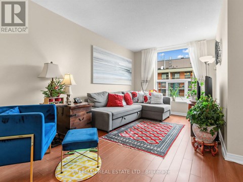 A living room with a grey couch, a blue chair, and a red rug.