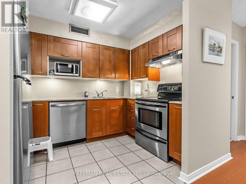 A kitchen with wooden cabinets and stainless steel appliances.
