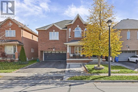 A large brick house with a tree in front.