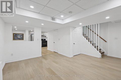 A spacious room with a staircase and a painting on the wall.