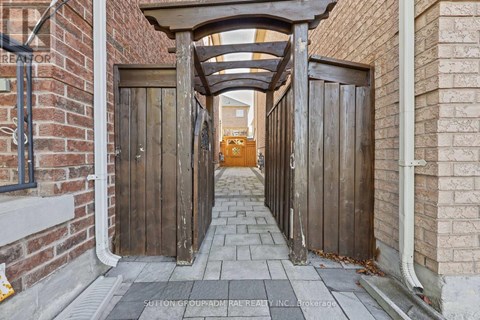 A wooden gate leads to a building with a brick wall on either side.