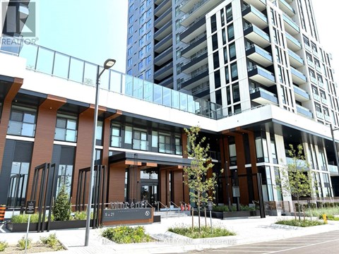 A modern building with a glass facade and a brown entrance.