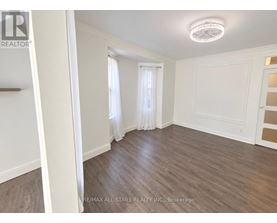 A room with wooden flooring and white walls.