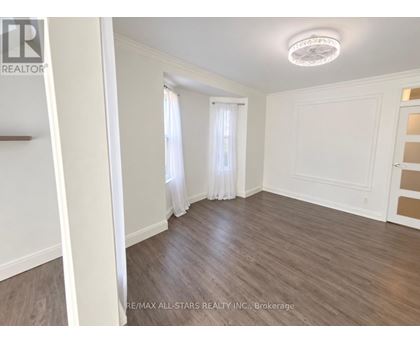 A room with wooden flooring and white walls.