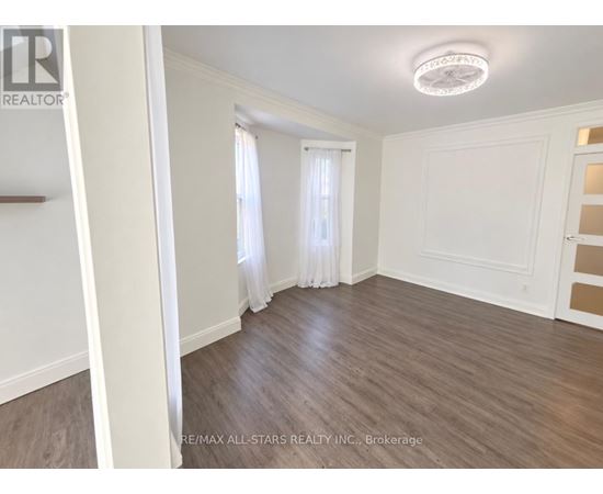 A room with wooden flooring and white walls.