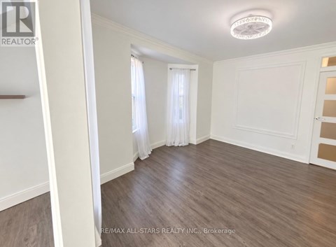 A room with wooden flooring and white walls.