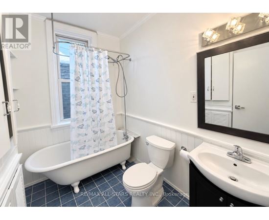 A white toilet sits next to a white bathtub in a bathroom.
