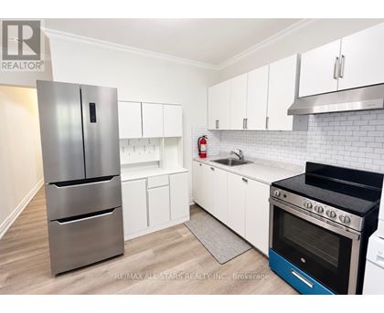 A kitchen with white cabinets and a stainless steel refrigerator.