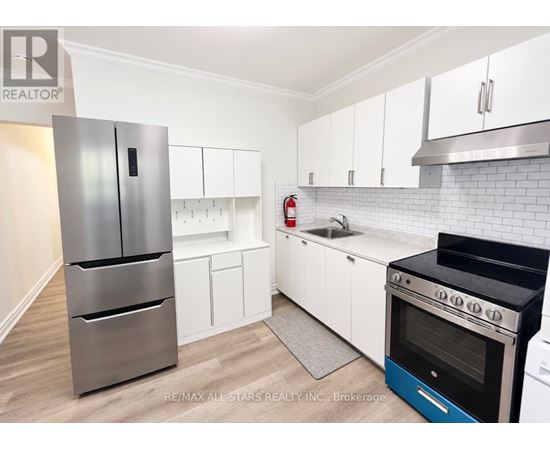A kitchen with white cabinets and a stainless steel refrigerator.