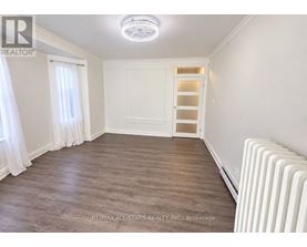 A room with a white ceiling, a white door, and a white radiator.