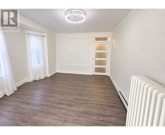 A room with a white ceiling, a white door, and a white radiator.