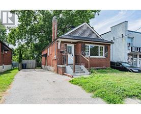 A brick house with a porch and a driveway in front.