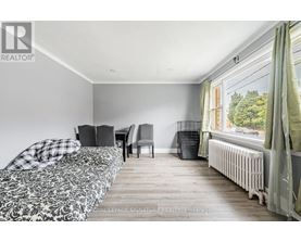 A bedroom with a bed, chair, and window.