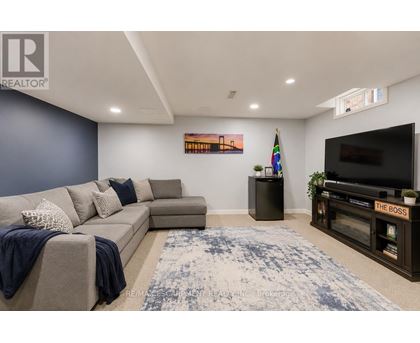 A living room with a grey couch and a blue rug.