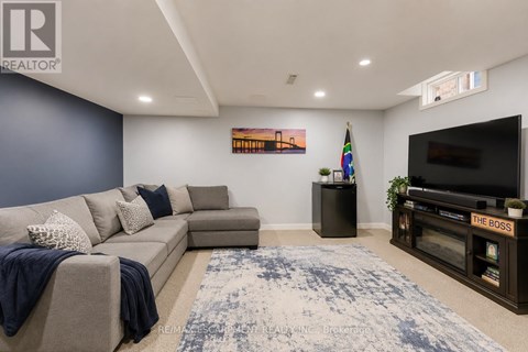 A living room with a grey couch and a blue rug.
