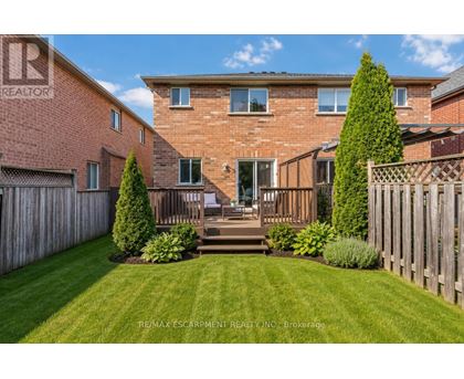 A house with a red brick exterior and a wooden fence.