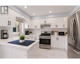A modern kitchen with white cabinets and stainless steel appliances.