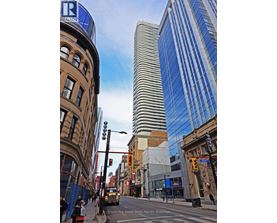 A street view of a city with a tall building in the background.