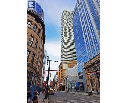 A street view of a city with a tall building in the background.