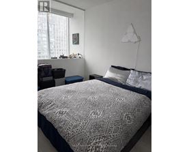 A bedroom with a large bed and a window.