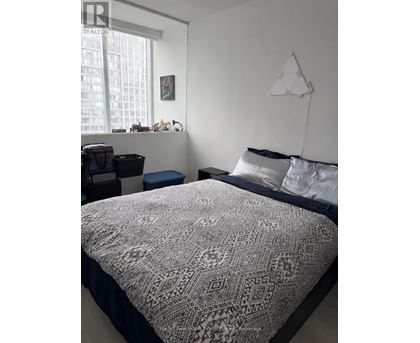 A bedroom with a large bed and a window.