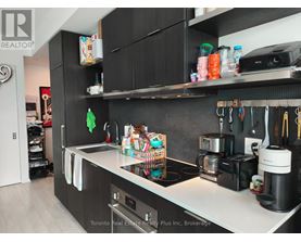 A kitchen with black cabinets and a white countertop.