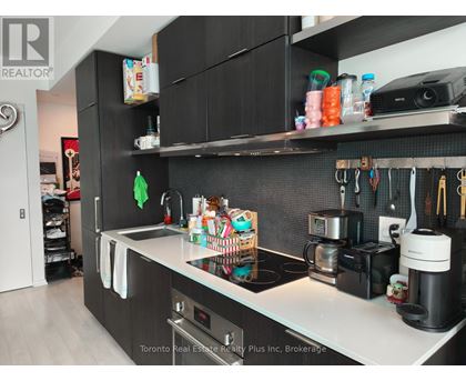A kitchen with black cabinets and a white countertop.