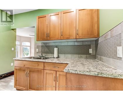 A kitchen with wooden cabinets and a marble countertop.