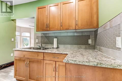 A kitchen with wooden cabinets and a marble countertop.