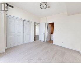 A white bedroom with a carpeted floor and a ceiling fan.