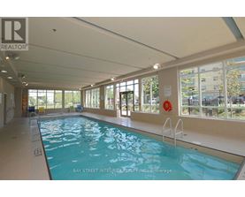 A large indoor swimming pool with a glass wall on one side.