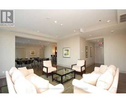 A living room with white couches and a glass coffee table.