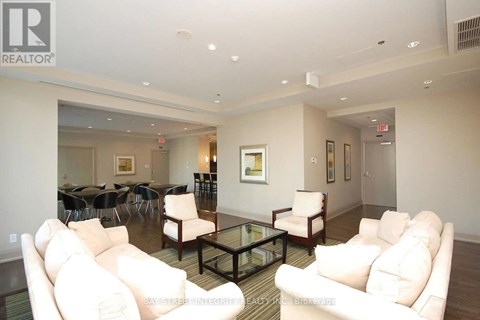 A living room with white couches and a glass coffee table.