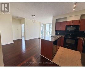 A kitchen with dark wood cabinets and a black oven.