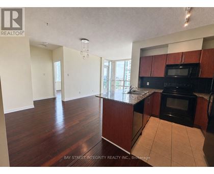 A kitchen with dark wood cabinets and a black oven.
