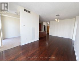 A spacious room with wooden floors and white walls.