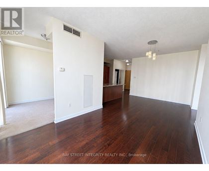 A spacious room with wooden floors and white walls.