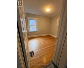 A room with wooden flooring and a window.