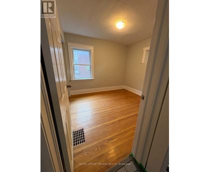 A room with wooden flooring and a window.
