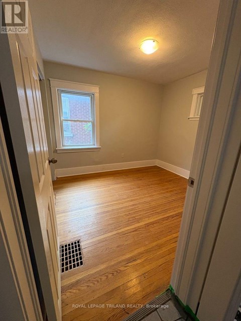 A room with wooden flooring and a window.