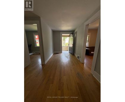 A long hallway with wood floors and white walls.