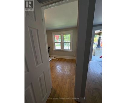 A room with a white door and wooden flooring.