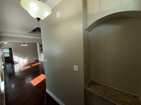 A hallway with a light on the ceiling and orange mats on the floor.