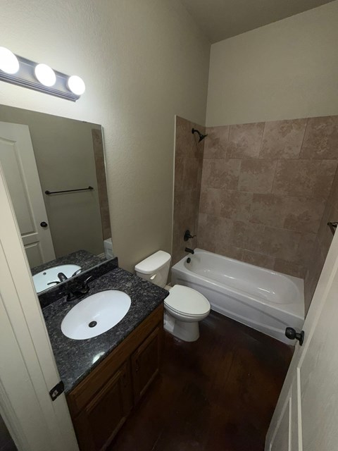 A bathroom with a sink, toilet, and bathtub.