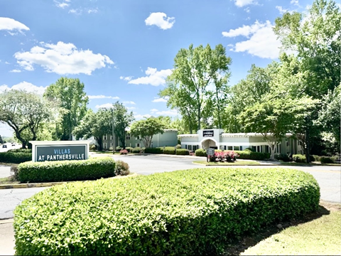 A sign that says Villas at Panthersville in front of a building.