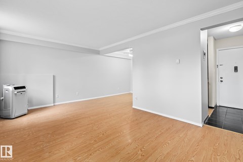 A room with wooden flooring and white walls.