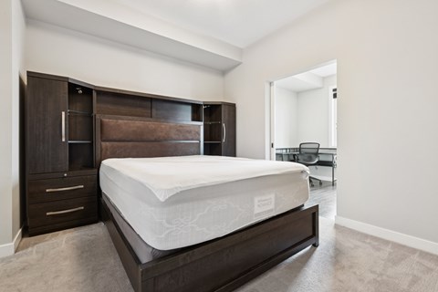 A bedroom with a large bed and a brown headboard.