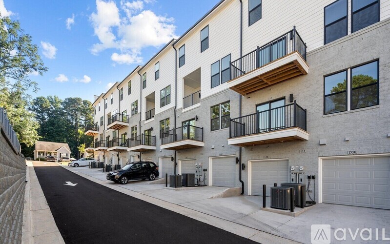 A street view of apartment buildings with cars parked on the side.